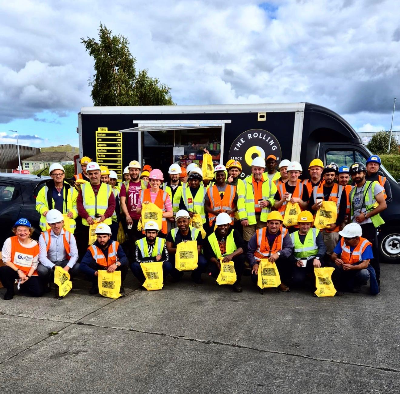 Construction crew in hi-vis gathered in front of the van